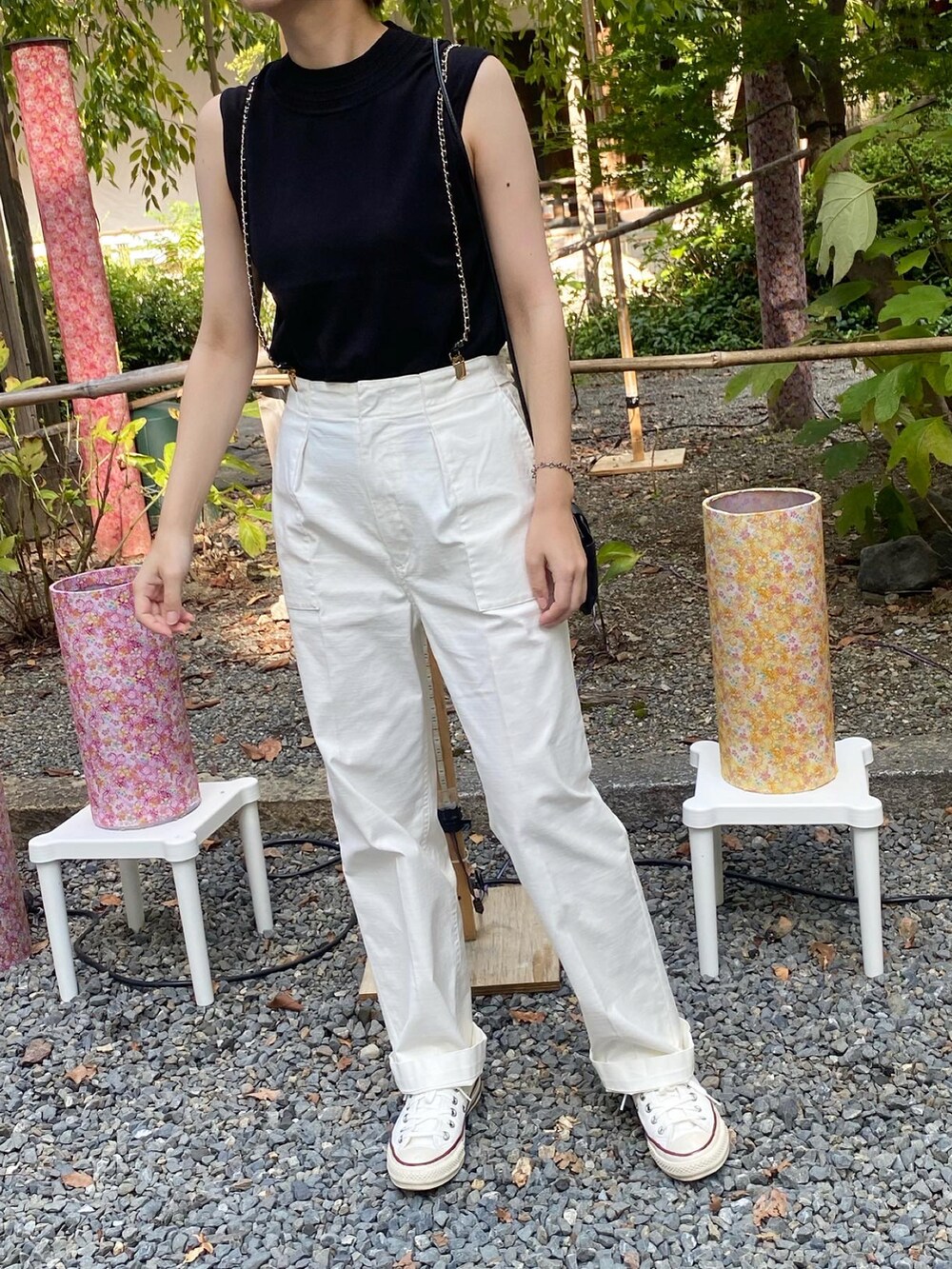 グレー系のトップス、ホワイト系のカーゴパンツ、ブラック系のサスペンダーを着用したレディースの夏コーディネートの2枚目の写真
