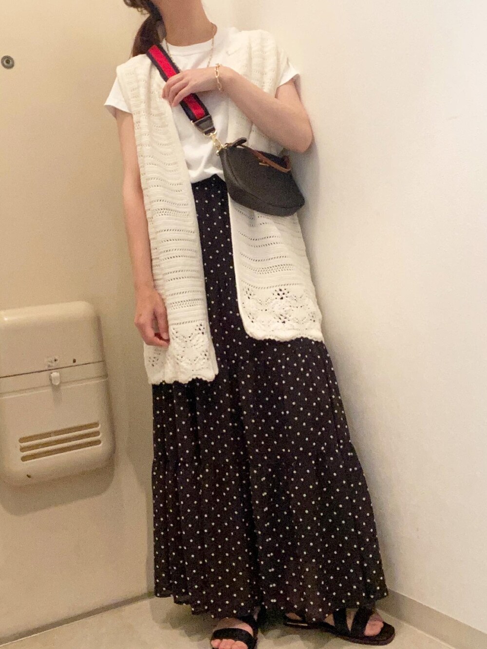 ブラック系のスカート、ホワイト系のベスト、ホワイト系のTシャツ/カットソーを着用したレディースの夏コーディネートの3枚目の写真