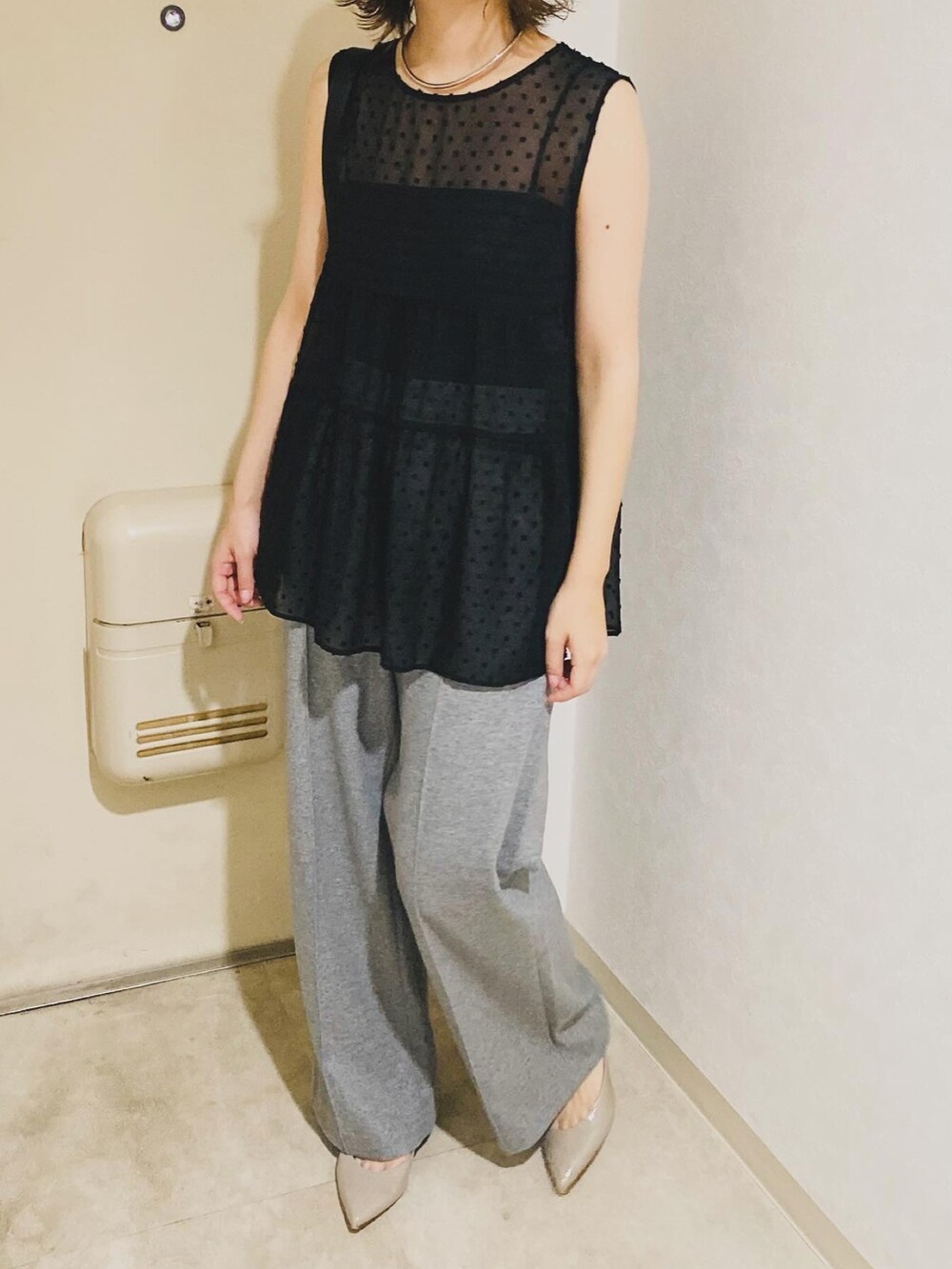 ブラック系のシャツ/ブラウス、グレー系のパンツを着用したレディースの秋コーディネートの2枚目の写真