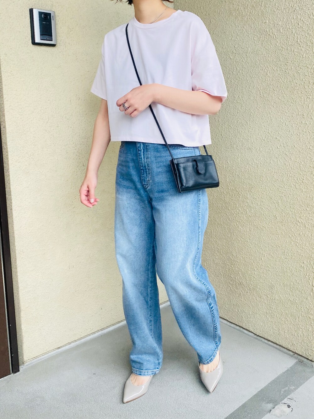 ブルー系のデニムパンツ、ピンク系のTシャツ/カットソー、グレー系のパンプスを着用したレディースの夏コーディネートの2枚目の写真