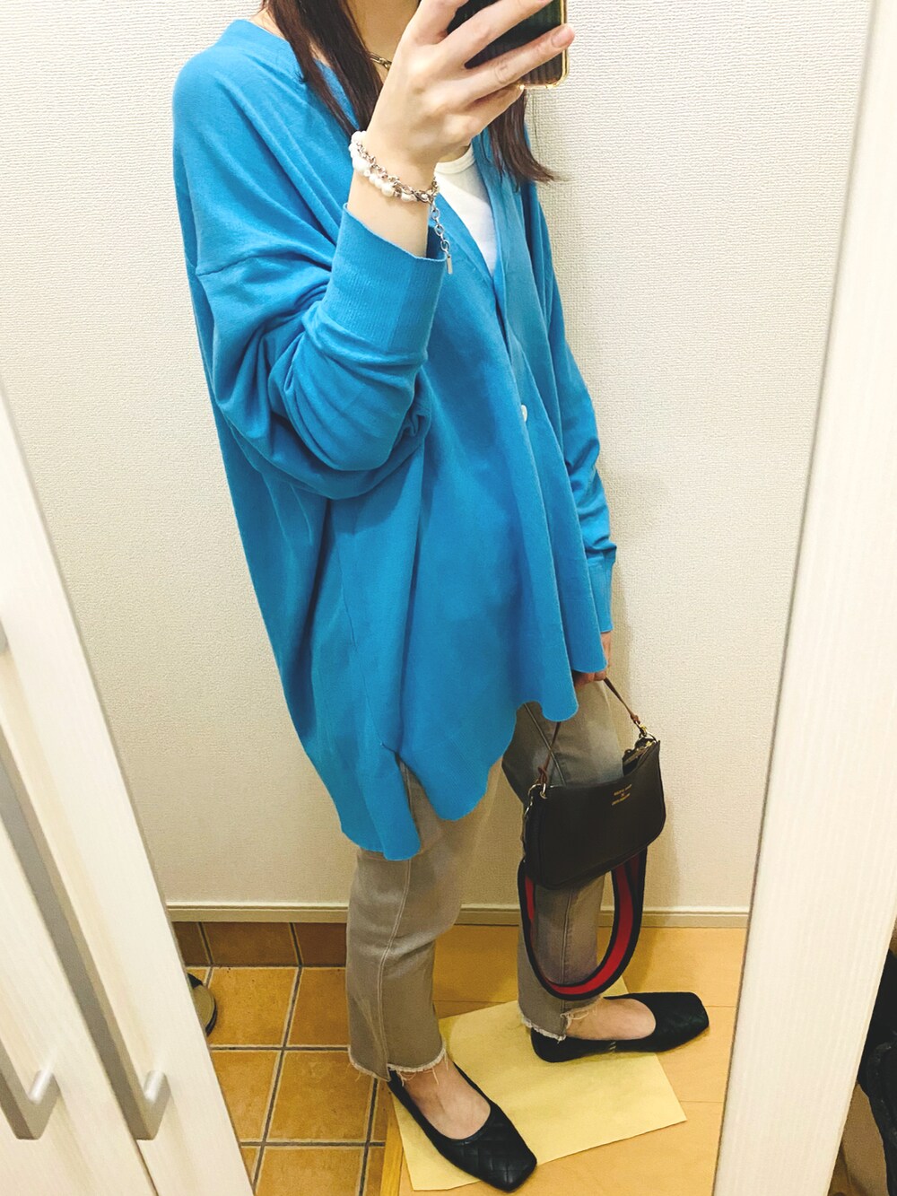 ブルー系のカーディガン/ボレロ、ホワイト系のタンクトップ、その他のバッグを着用したレディースの春コーディネートの3枚目の写真