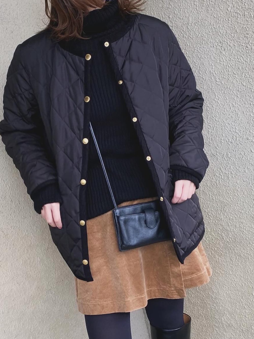 ブラック系のニット/セーター、ブラウン系のスカート、ブラック系のブーツを着用したレディースの冬コーディネートの4枚目の写真