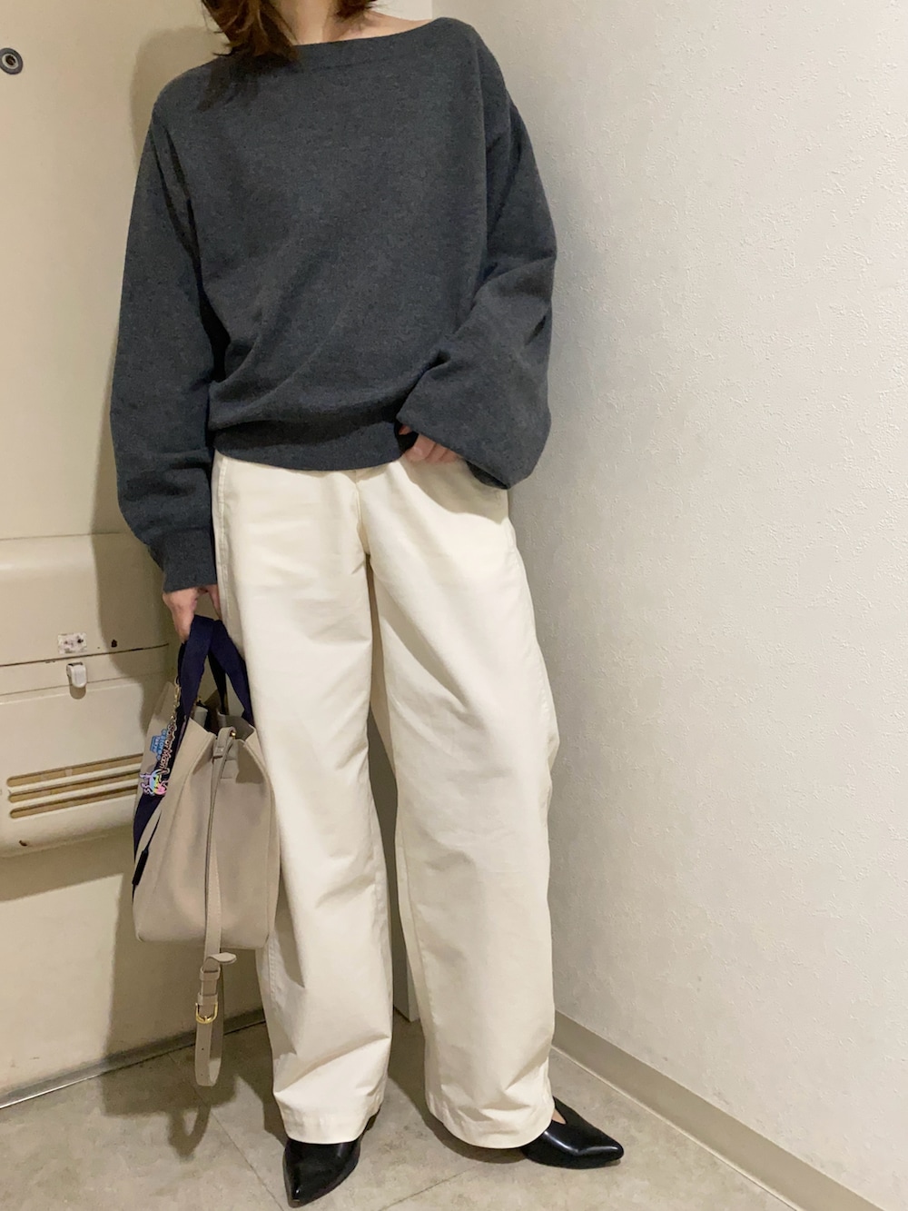 グレー系のニット/セーター、ホワイト系のパンツ、ブルー系のトートバッグを着用したレディースの冬コーディネートの3枚目の写真