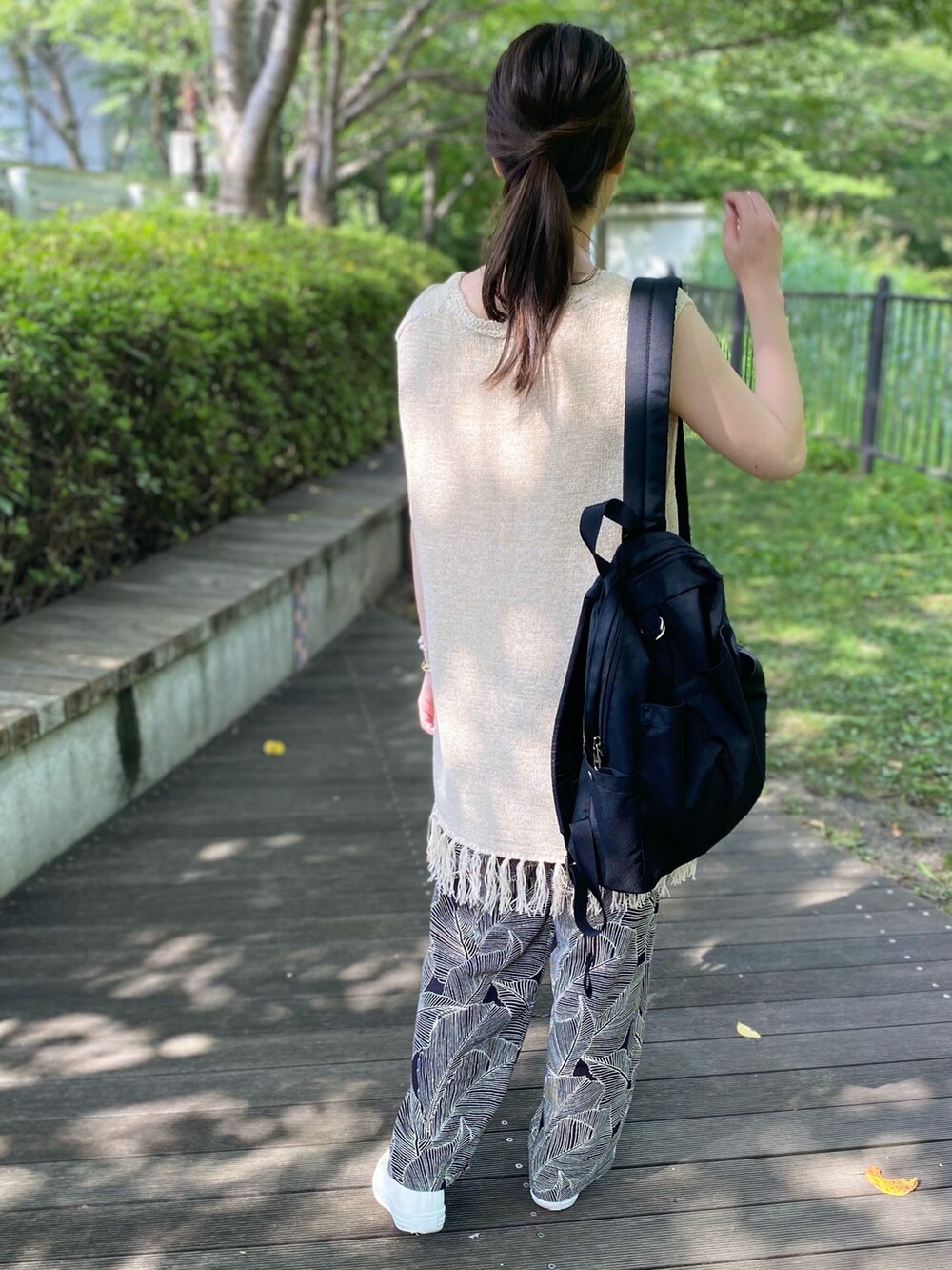 ベージュ系のベスト、ホワイト系のタンクトップ、ブラック系のその他パンツを着用したレディースの夏コーディネートの3枚目の写真