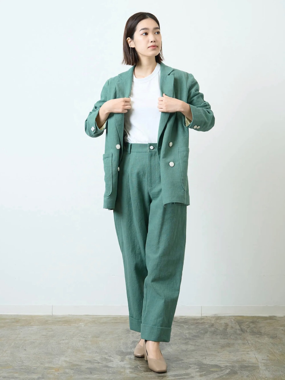 グリーン系のテーラードジャケット、グリーン系のその他パンツを着用したレディースの春コーディネートの2枚目の写真