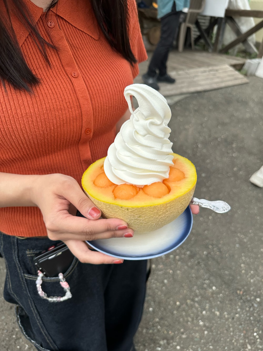 ブラック系のサンダル、オレンジ系のパンツ、ベージュ系のベストを着用したレディースの夏コーディネートの2枚目の写真