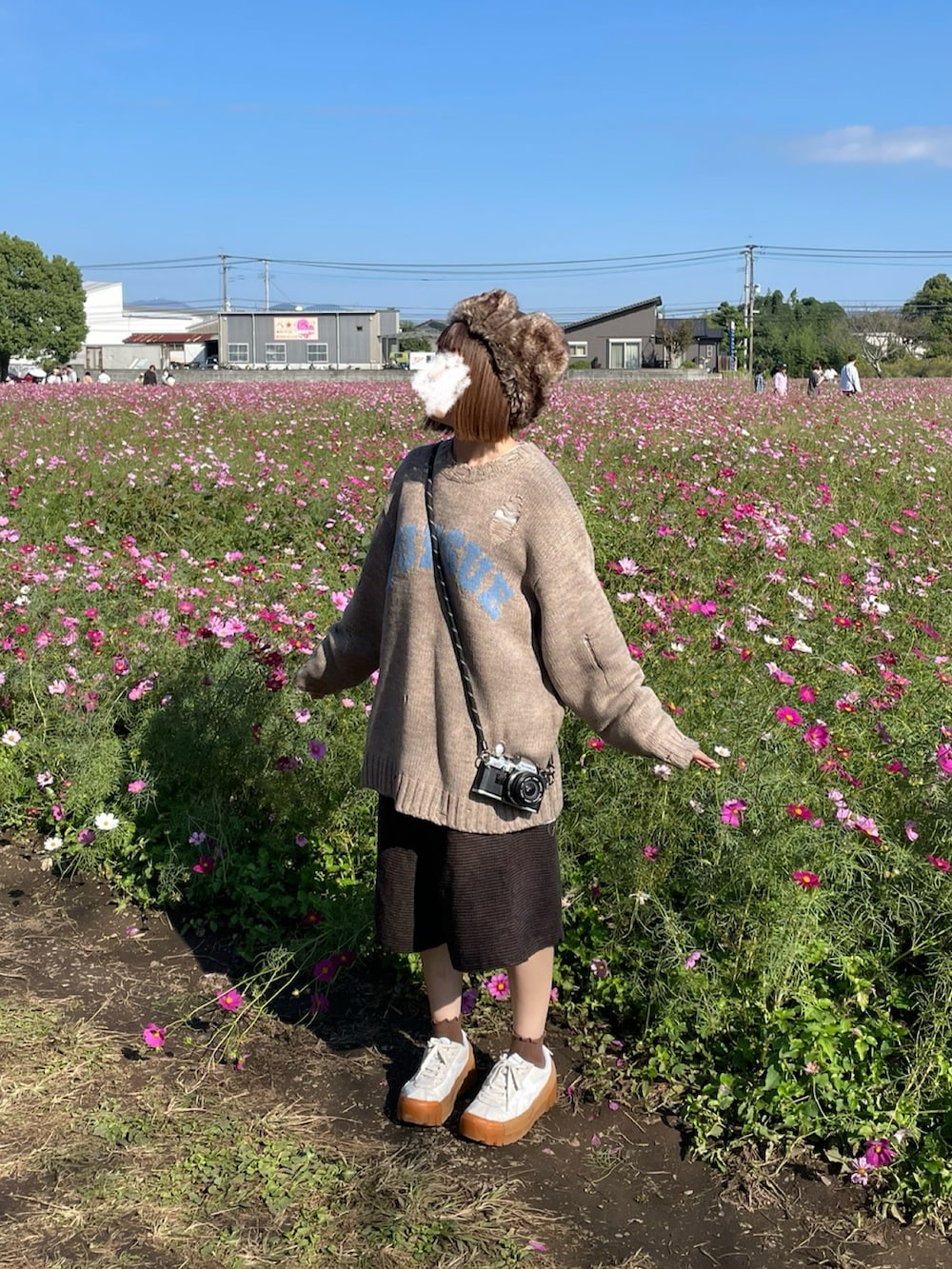 ベージュ系のニット/セーター、ブラウン系のその他パンツ、ホワイト系のスニーカーを着用したレディースの秋コーディネートの2枚目の写真