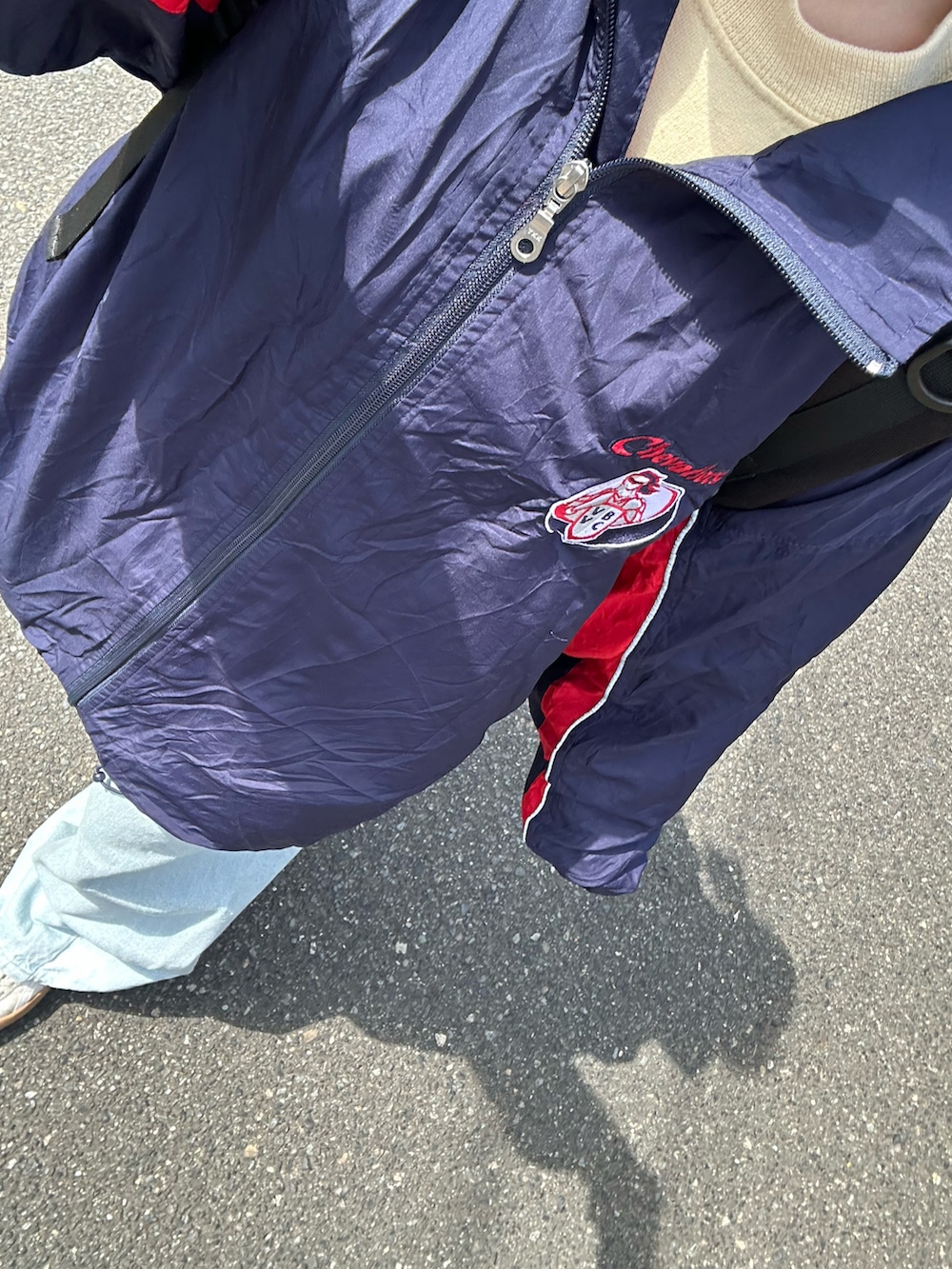 ホワイト系のスニーカー、ブルー系のデニムパンツ、ブラック系のバックパック/リュックを着用したレディースの春コーディネートの2枚目の写真