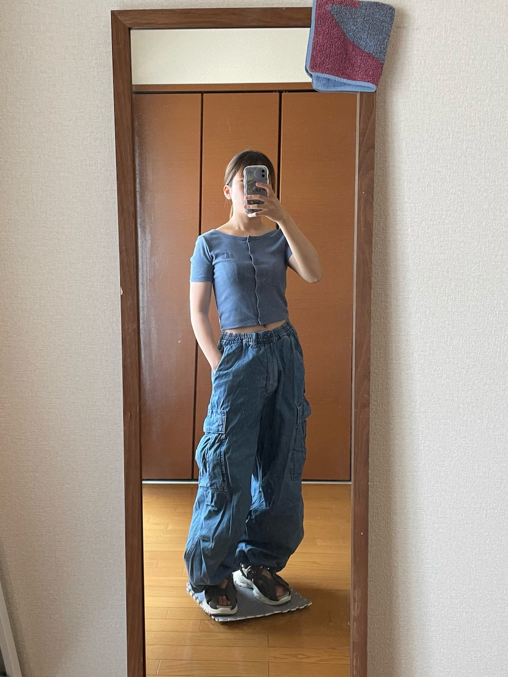 ブルー系のTシャツ/カットソー、ブルー系のカーゴパンツ、ブラック系のサンダルを着用したレディースの秋コーディネートの2枚目の写真