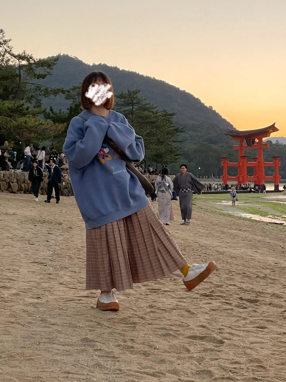 ブルー系のスウェット、ベージュ系のスカート、ホワイト系のスニーカーを着用したレディースの秋コーディネートの2枚目の写真