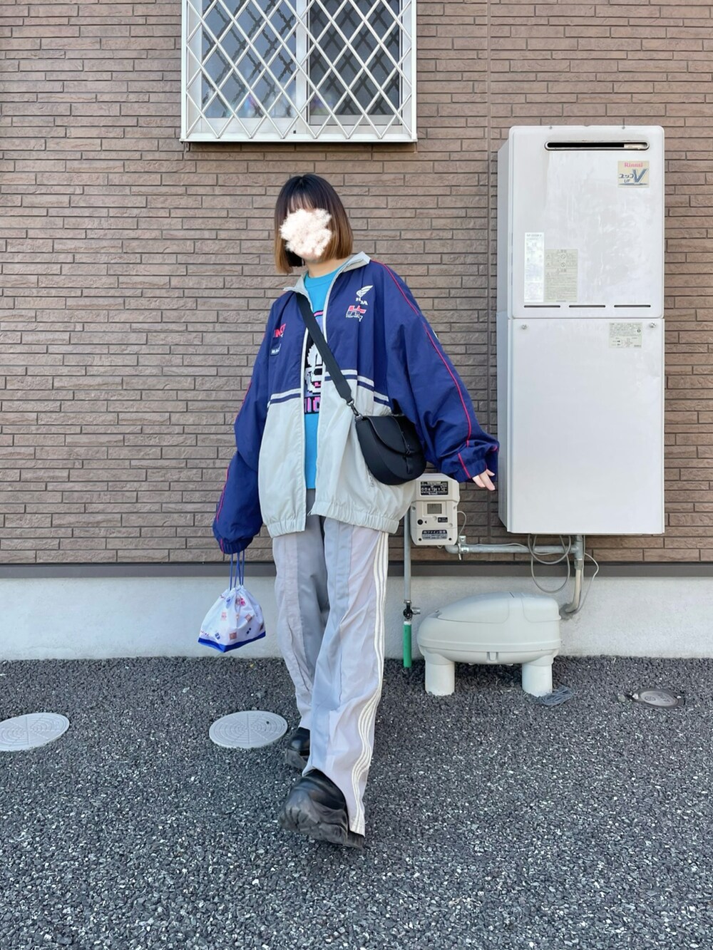 ブルー系のブルゾン、グレー系のスウェットパンツ、ブラック系のブーツを着用したレディースの春コーディネートの2枚目の写真