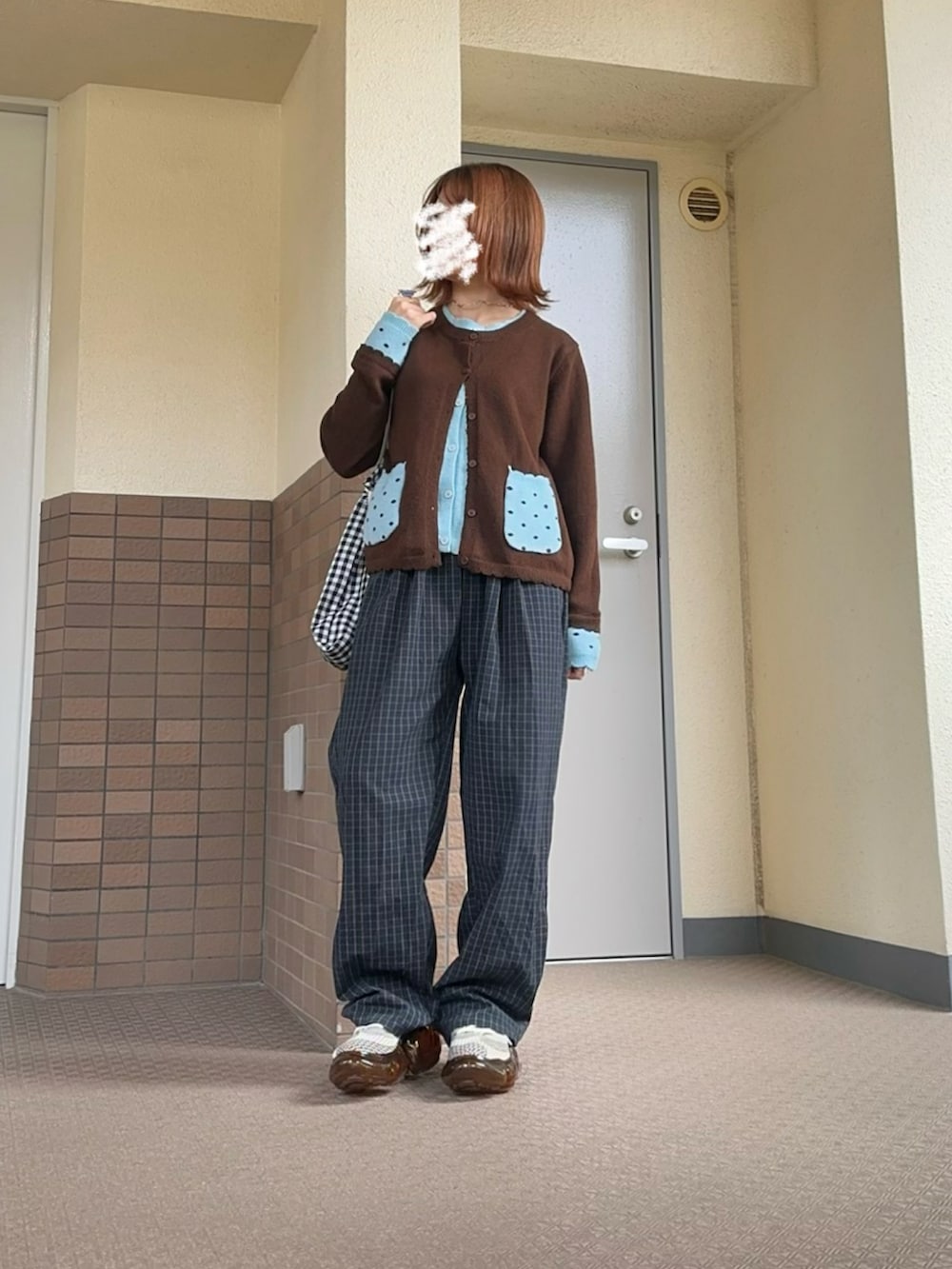 ブラウン系のニット/セーター、ブルー系のパンツ、ブラウン系のシューズを着用したレディースの春コーディネートの2枚目の写真