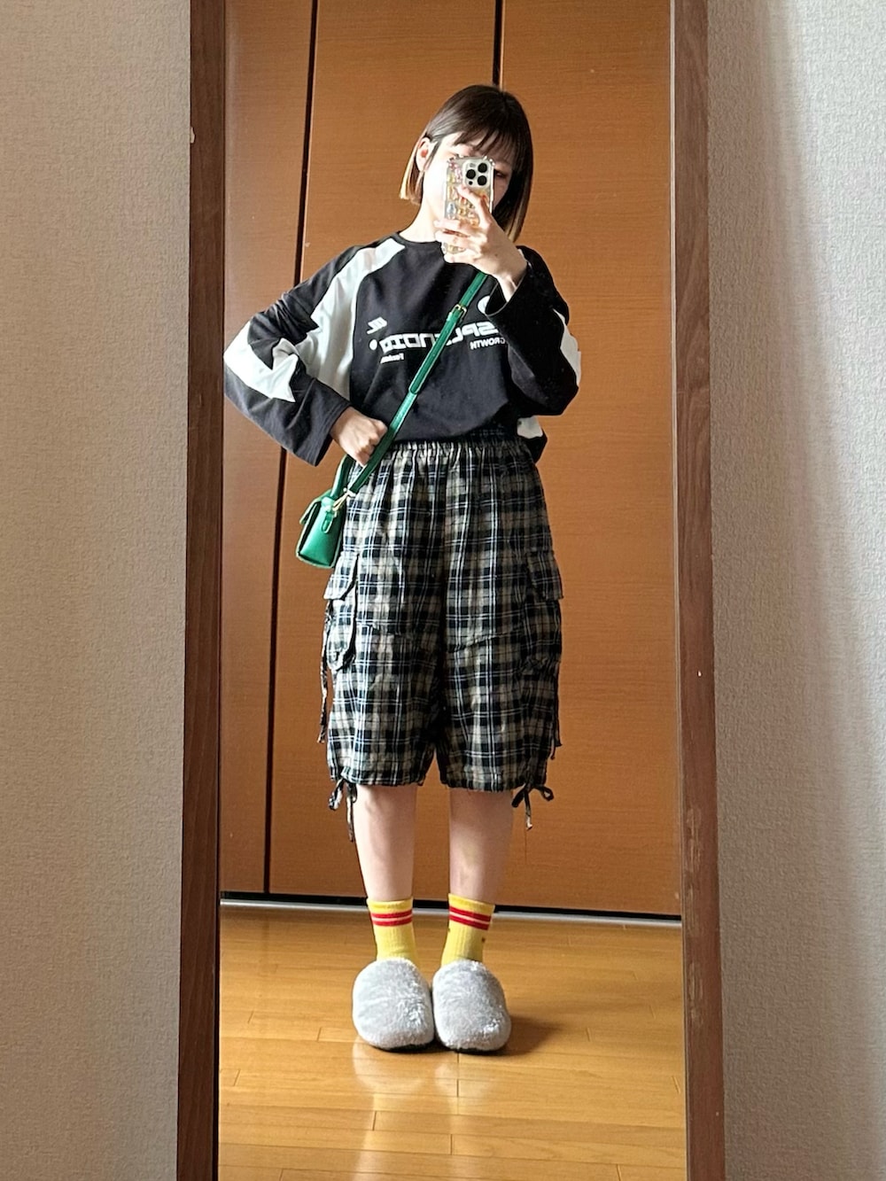 グリーン系のショルダーバッグ、ブラック系のTシャツ/カットソー、ブルー系のパンツを着用したレディースの秋コーディネートの2枚目の写真