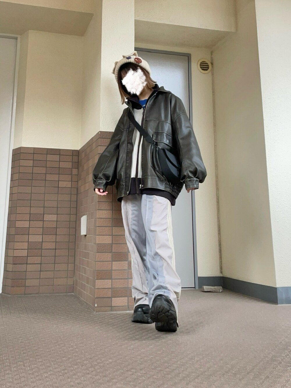 ブラック系のブーツ、グレー系のスウェットパンツ、ブラック系のショルダーバッグを着用したレディースの春コーディネートの2枚目の写真