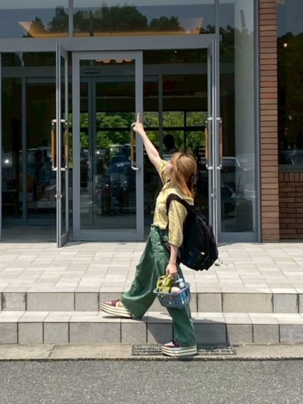レッド系のスニーカー、イエロー系のシャツ/ブラウス、グリーン系のチノパンツを着用したレディースの春コーディネートの2枚目の写真
