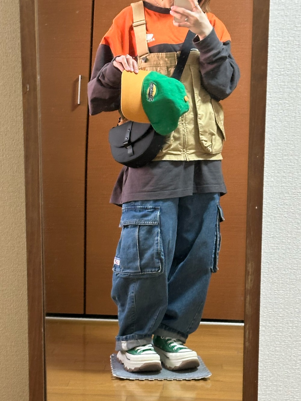 ブラック系のTシャツ/カットソー、ベージュ系のベスト、ブルー系のデニムパンツを着用したレディースの春コーディネートの2枚目の写真