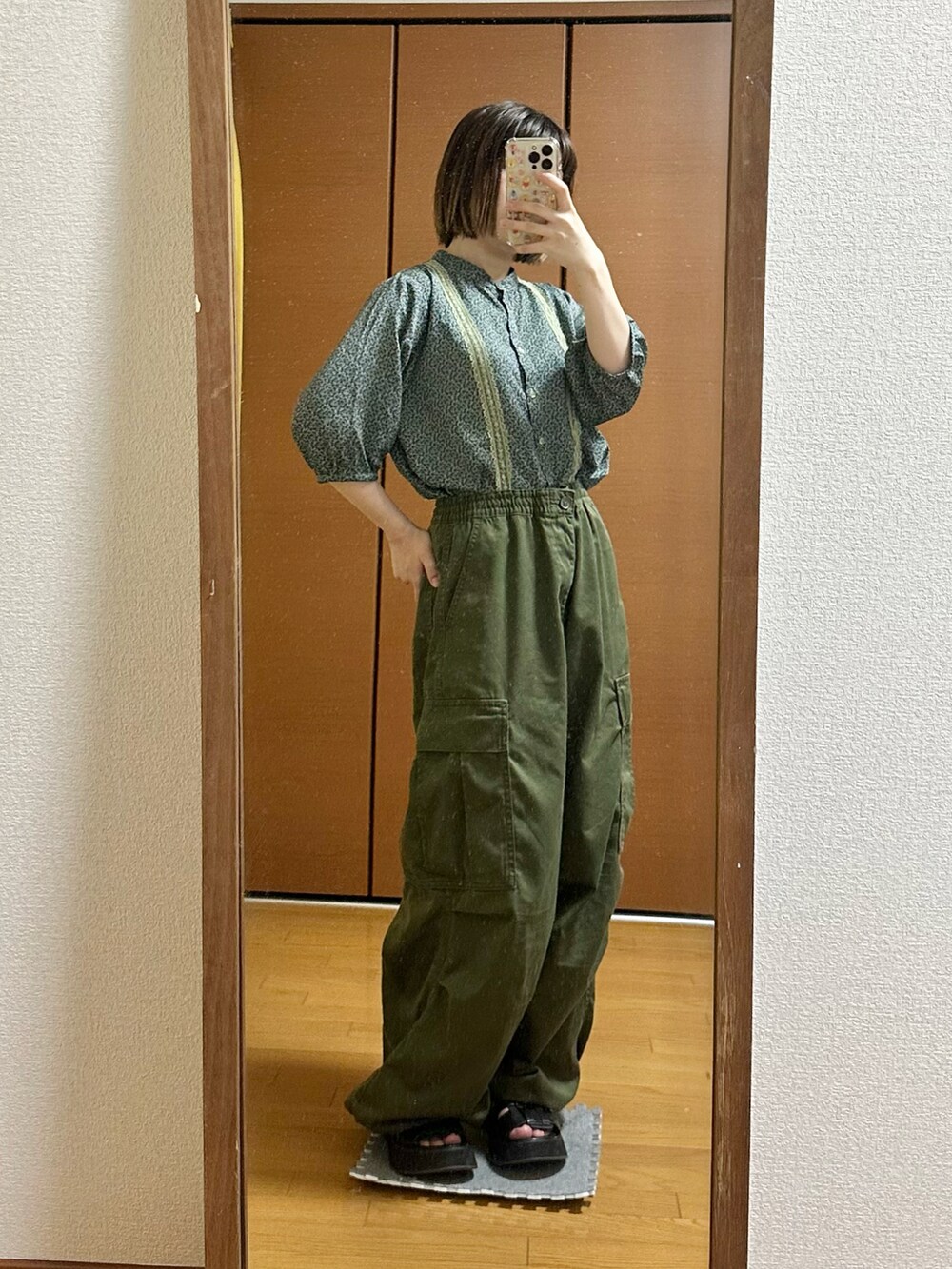 グリーン系のシャツ/ブラウス、ブラック系のサンダル、グリーン系のパンツを着用したレディースの夏コーディネートの2枚目の写真