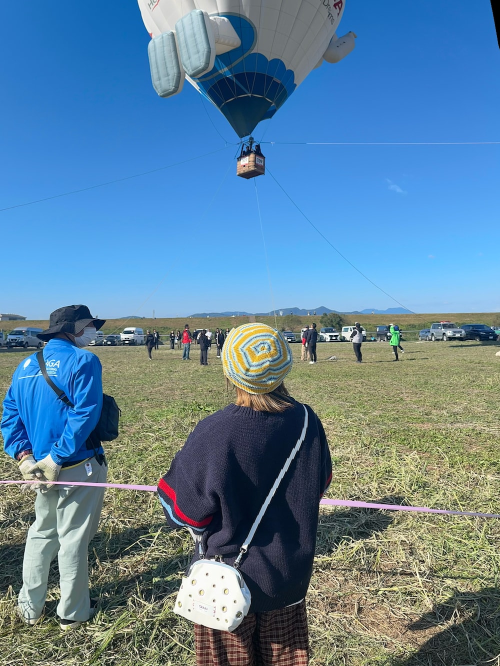 ブラウン系のその他パンツ、ブルー系のニット/セーター、ホワイト系のショルダーバッグを着用したレディースの秋コーディネートの2枚目の写真