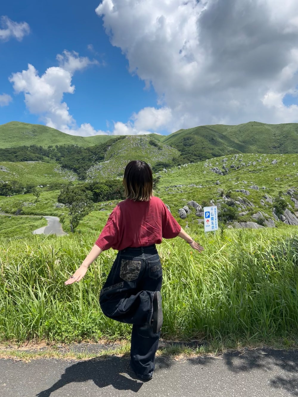 ブルー系のデニムパンツ、ブラック系のサンダル、レッド系のTシャツ/カットソーを着用したレディースの秋コーディネートの2枚目の写真