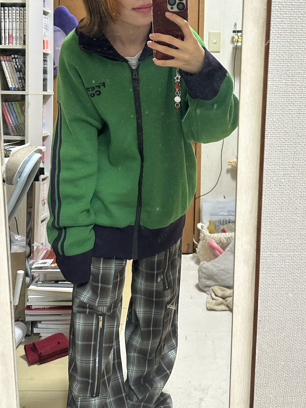 ホワイト系のショルダーバッグ、ブラック系のブーツ、グリーン系のブルゾンを着用したレディースの冬コーディネートの2枚目の写真