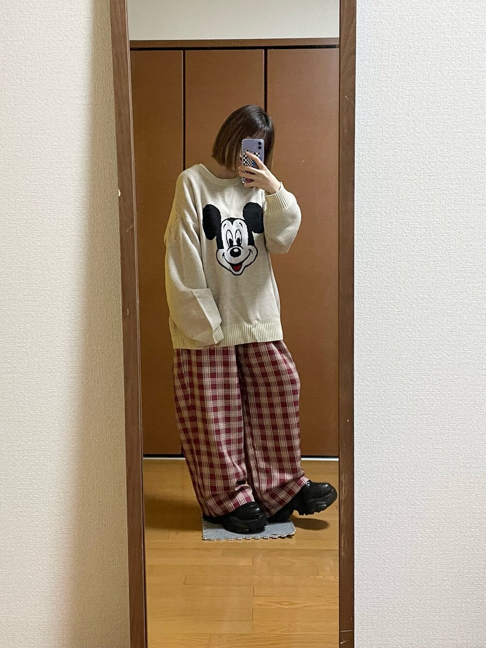 ホワイト系のニット/セーター、レッド系のスラックス、ブラック系のブーツを着用したレディースの冬コーディネートの2枚目の写真