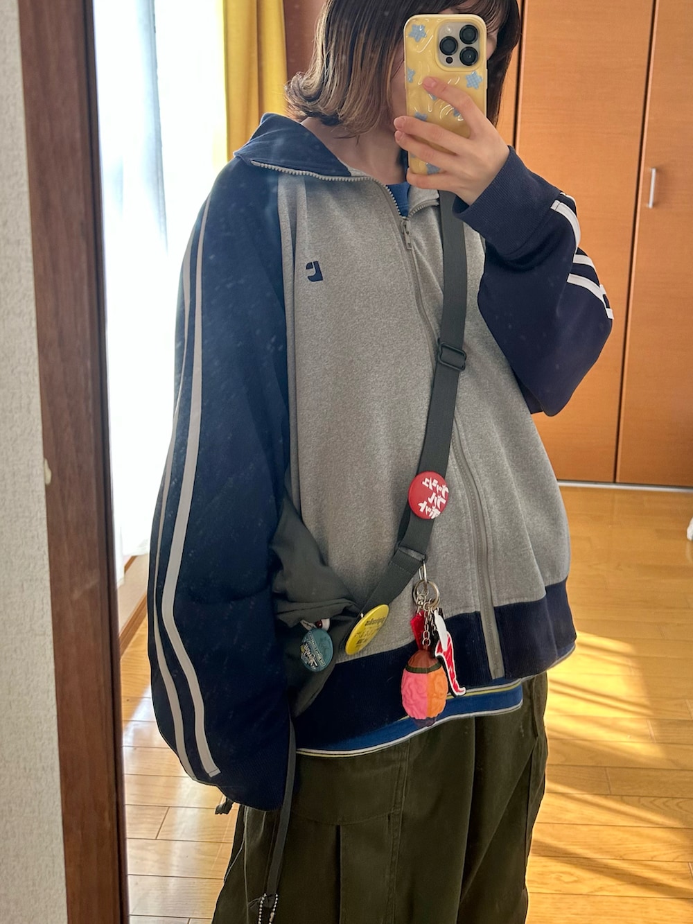 グレー系のブルゾン、ブラック系のブーツ、ブルー系のTシャツ/カットソーを着用したレディースの秋コーディネートの2枚目の写真