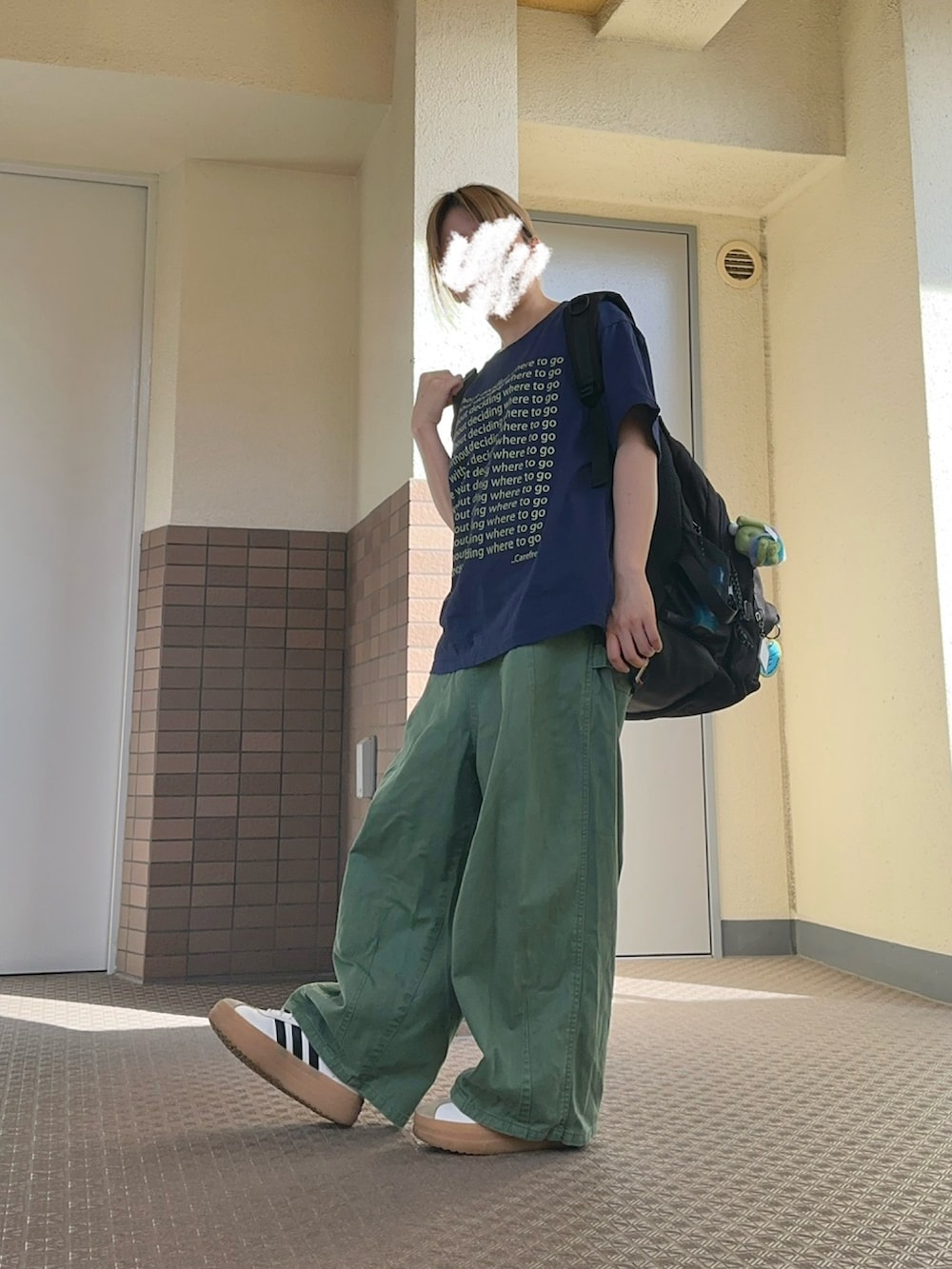 ホワイト系のスニーカー、グリーン系のチノパンツ、ブラック系のバックパック/リュックを着用したレディースの夏コーディネートの2枚目の写真