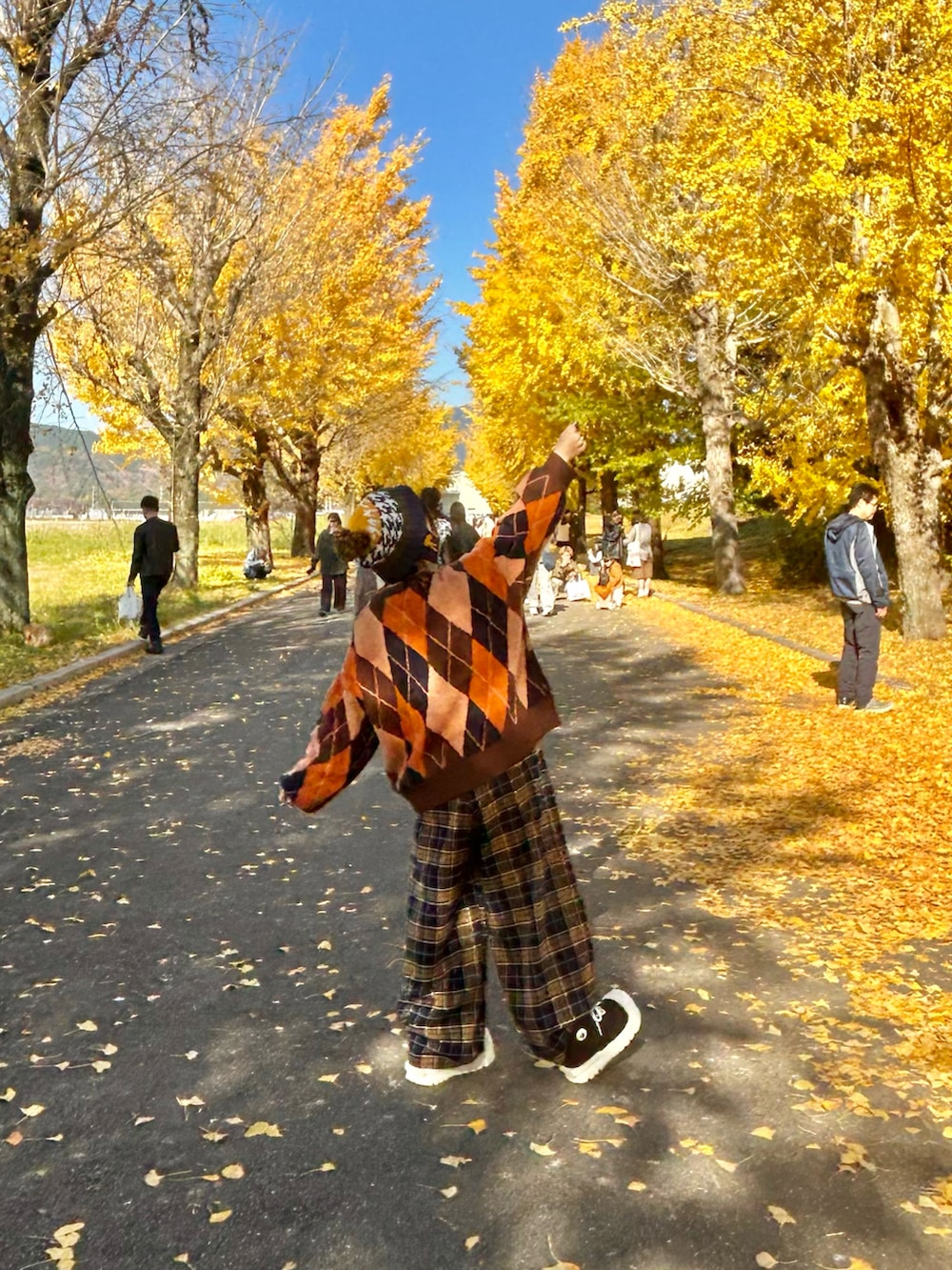 ブラック系のブーツ、オレンジ系のカーディガン/ボレロ、ブルー系のその他パンツを着用したレディースの冬コーディネートの2枚目の写真