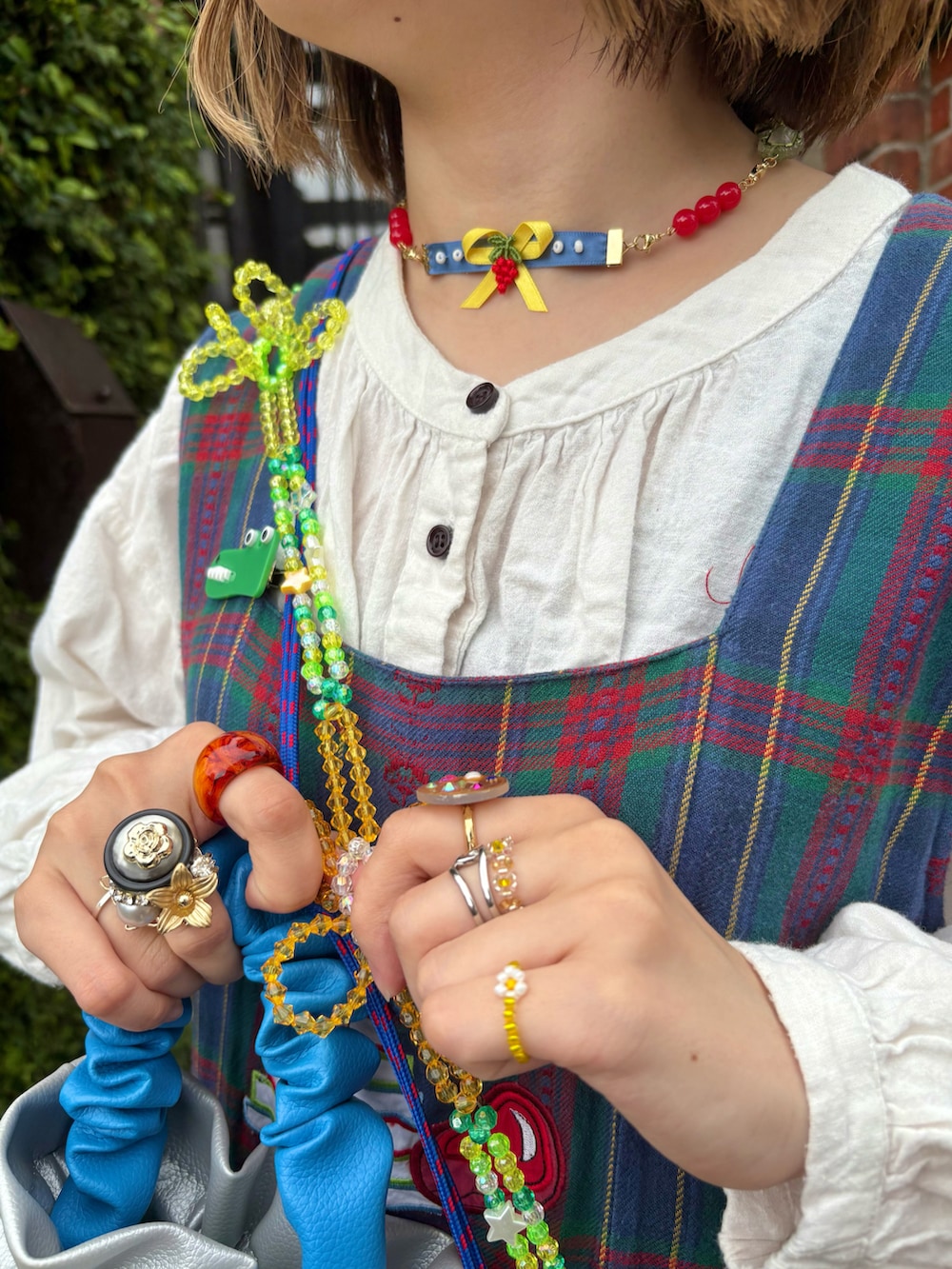 ブラウン系のその他シューズ、レッド系のスラックス、シルバー系のハンドバッグを着用したレディースの春コーディネートの2枚目の写真