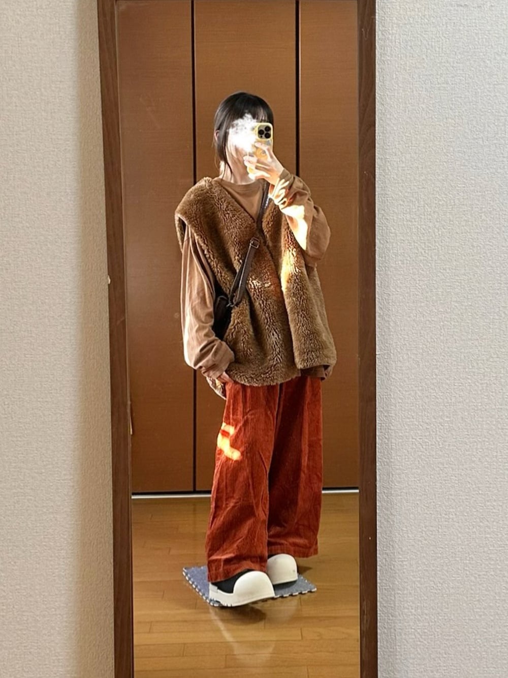 ブラウン系のベスト、ブラウン系のその他パンツ、ブラック系のブーツを着用したレディースの秋コーディネートの2枚目の写真