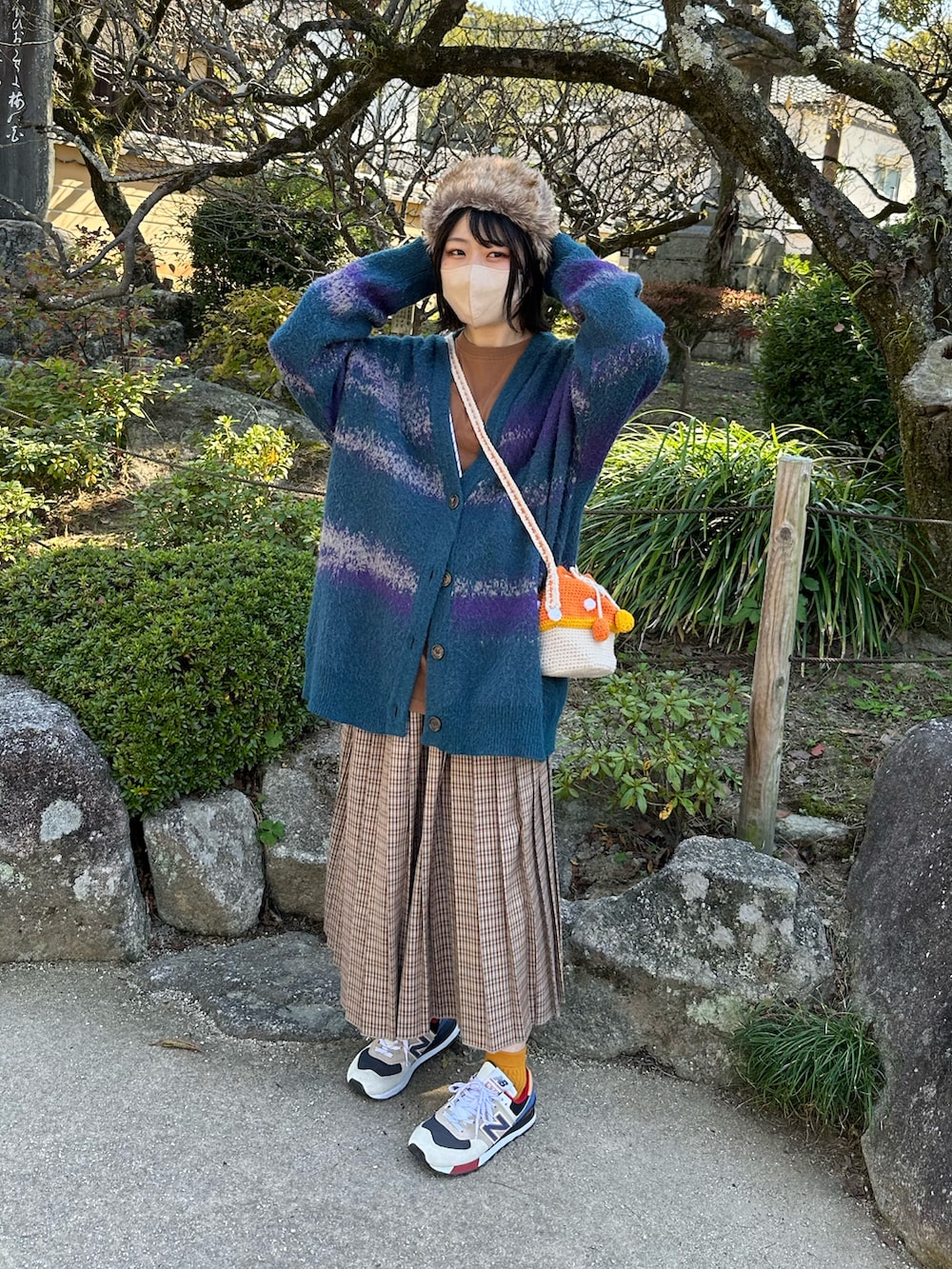 ベージュ系のスニーカー、ベージュ系のスカート、グリーン系のカーディガン/ボレロを着用したレディースの秋コーディネートの2枚目の写真