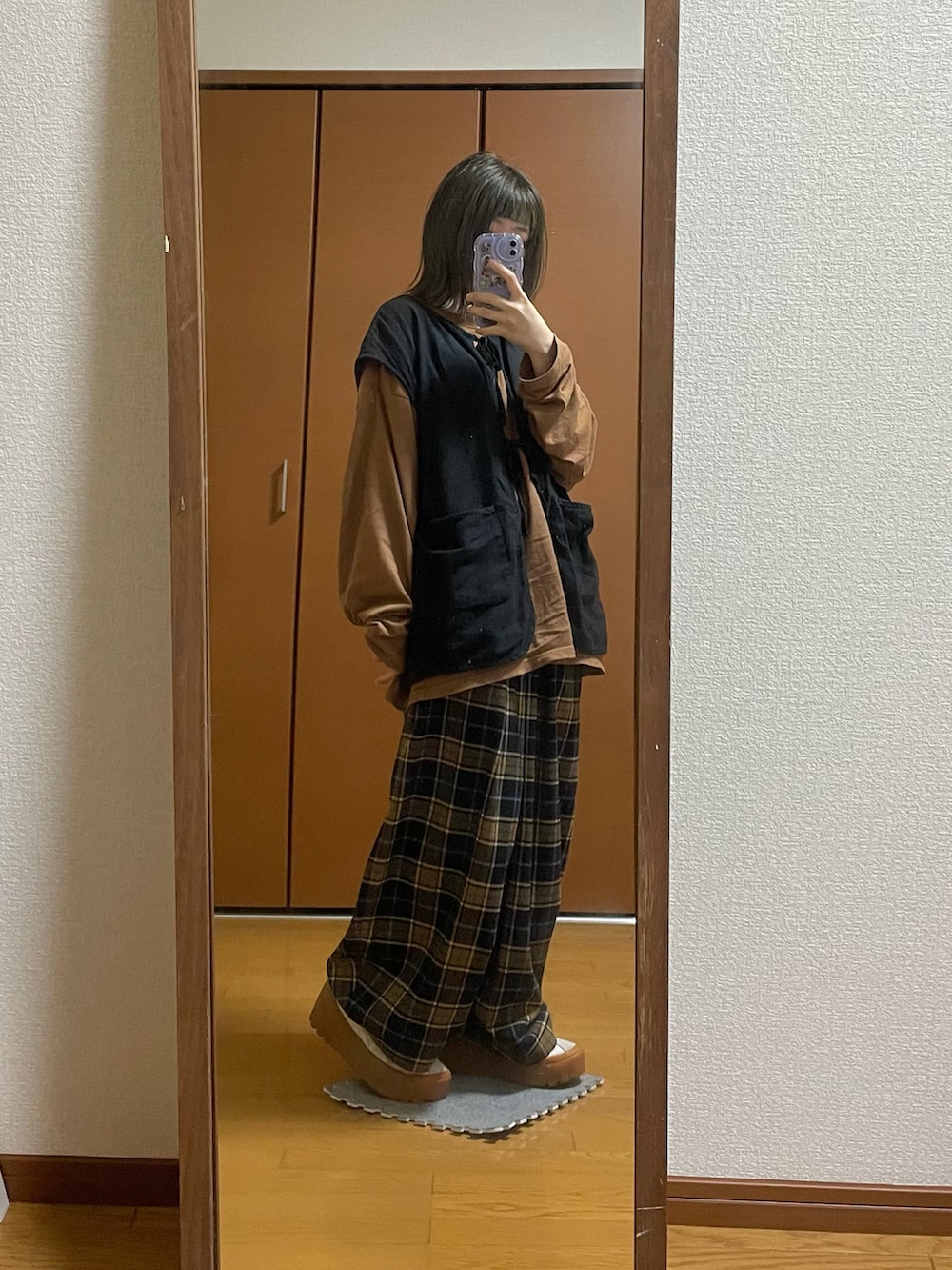 ホワイト系のスニーカー、ブルー系のその他パンツ、ブラック系のベストを着用したレディースの春コーディネートの2枚目の写真