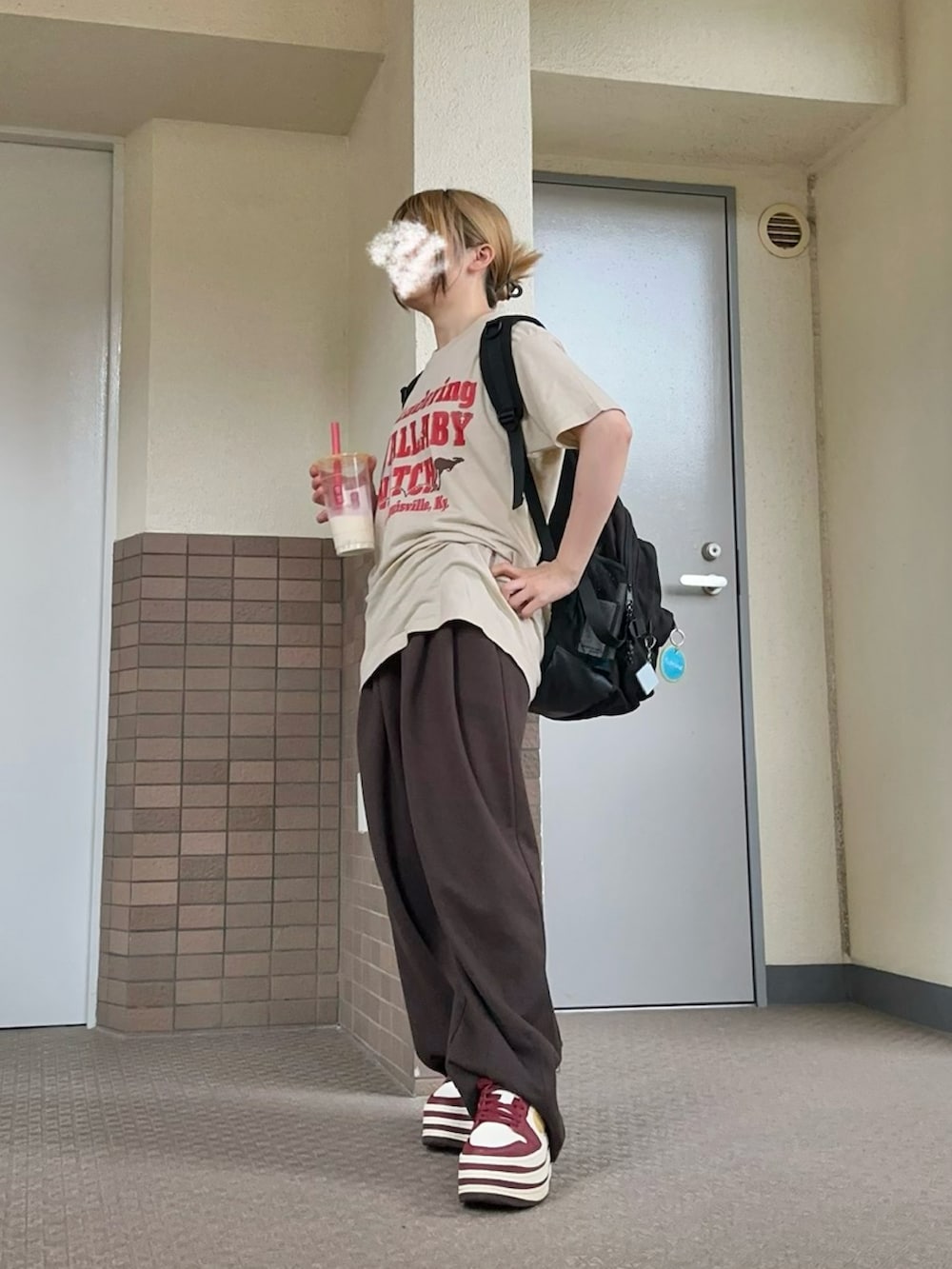 レッド系のスニーカー、ブラック系のバックパック/リュック、ベージュ系のTシャツ/カットソーを着用したレディースの夏コーディネートの2枚目の写真