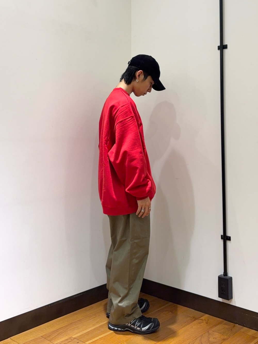レッド系のスウェット、ブラウン系のその他パンツ、ブラック系のスニーカーを着用したメンズの秋コーディネートの4枚目の写真