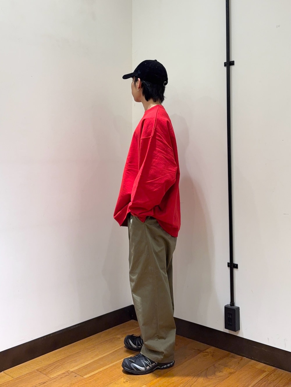 レッド系のスウェット、ブラウン系のその他パンツ、ブラック系のスニーカーを着用したメンズの秋コーディネートの2枚目の写真