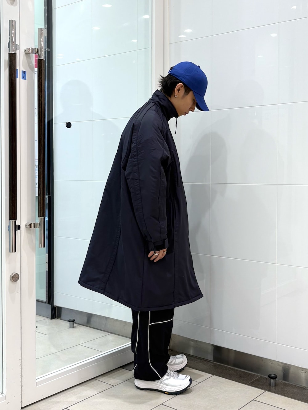 ブルー系のダウンジャケット/コート、ブラック系のその他パンツ、ホワイト系のスニーカーを着用したメンズの秋コーディネートの4枚目の写真