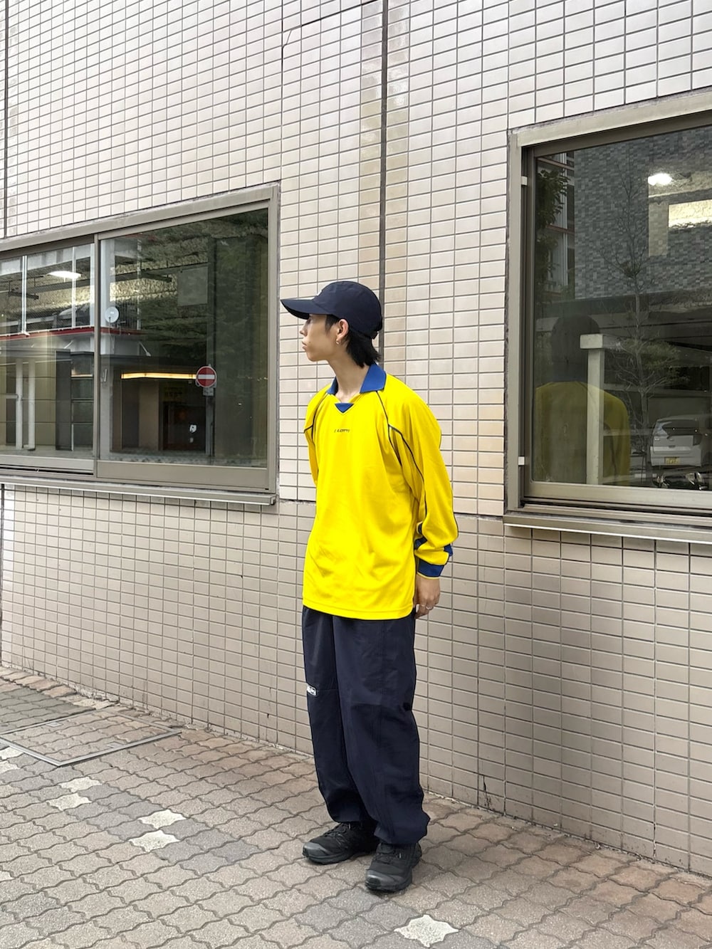 イエロー系のTシャツ/カットソー、ブルー系のその他パンツ、ブルー系のキャップを着用したメンズの秋コーディネートの2枚目の写真