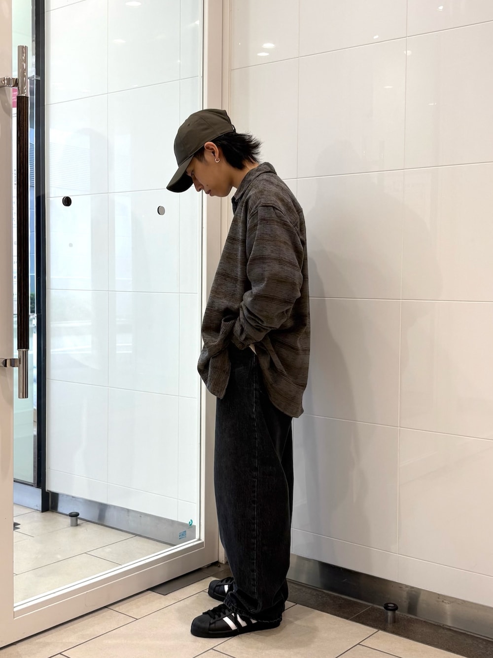 グレー系のシャツ/ブラウス、ベージュ系のTシャツ/カットソー、ブラック系のデニムパンツを着用したメンズの秋コーディネートの2枚目の写真