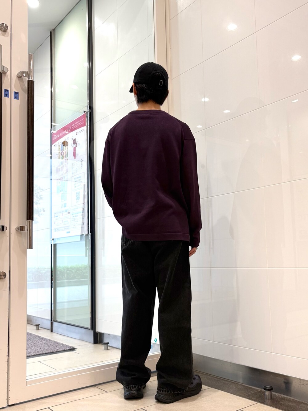 パープル系のニット/セーター、ブラック系のデニムパンツ、ブラック系のスニーカーを着用したメンズの秋コーディネートの3枚目の写真