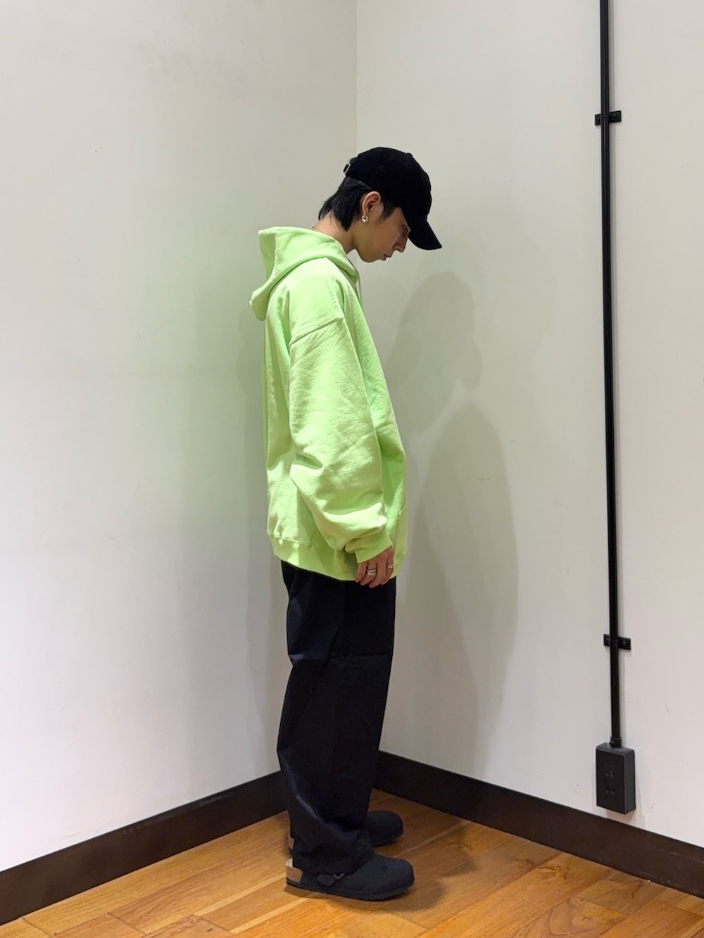 グリーン系のパーカー、ブラック系のその他パンツ、ブラック系のサンダルを着用したメンズの秋コーディネートの4枚目の写真