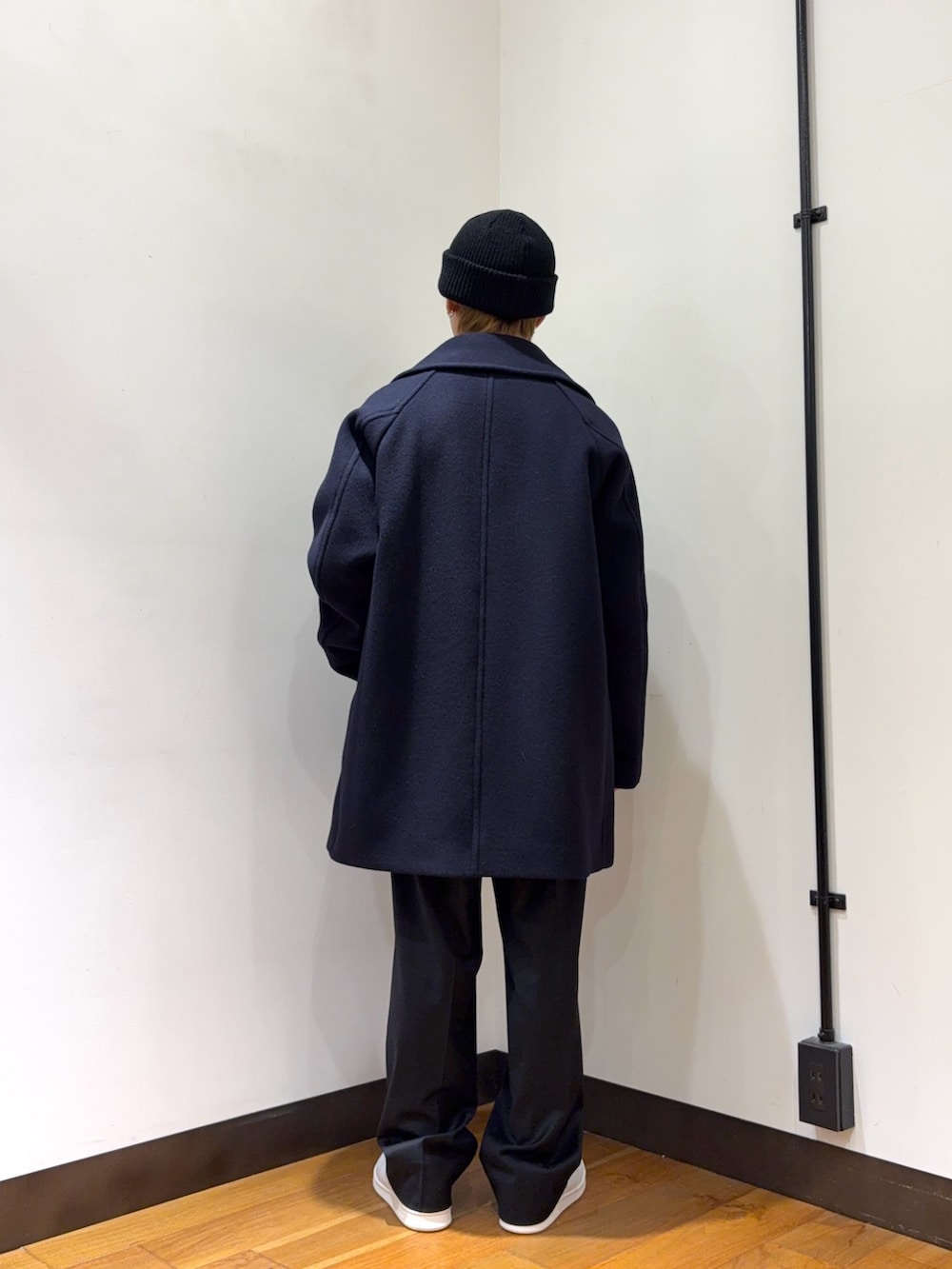 ブルー系のピーコート、グレー系のカーディガン/ボレロ、ブラック系のその他パンツを着用したメンズの冬コーディネートの3枚目の写真