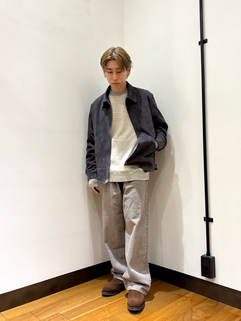 グレー系のブルゾン、グレー系のスウェット、ブラウン系のデニムパンツを着用したメンズの冬コーディネートの5枚目の写真