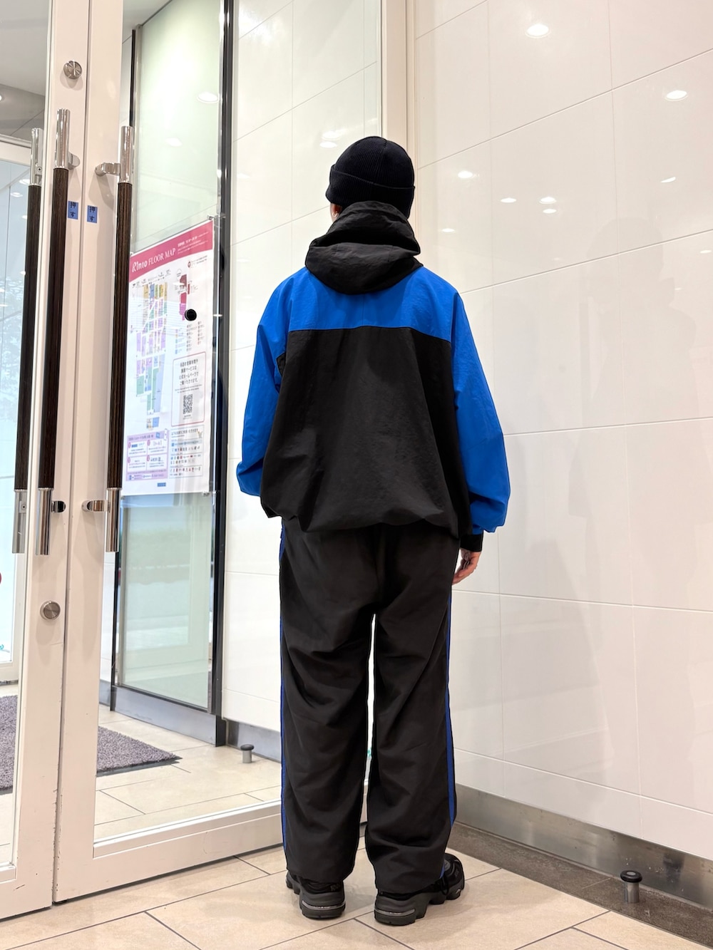 ブルー系のナイロンジャケット、ブルー系のその他パンツ、ブラック系のスニーカーを着用したメンズの秋コーディネートの4枚目の写真