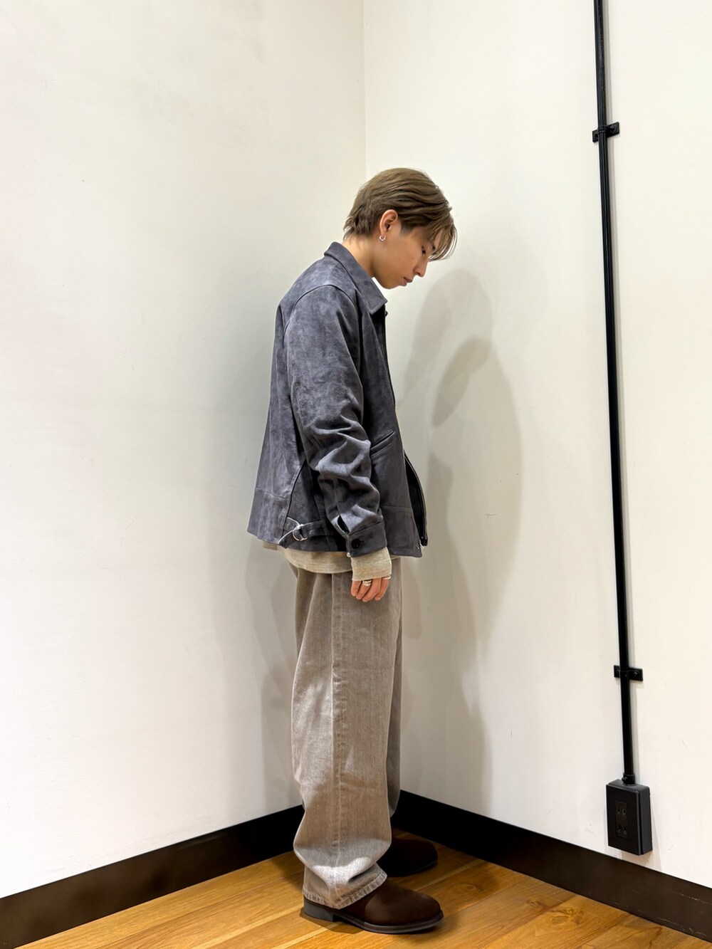 グレー系のブルゾン、グレー系のスウェット、ブラウン系のデニムパンツを着用したメンズの冬コーディネートの4枚目の写真