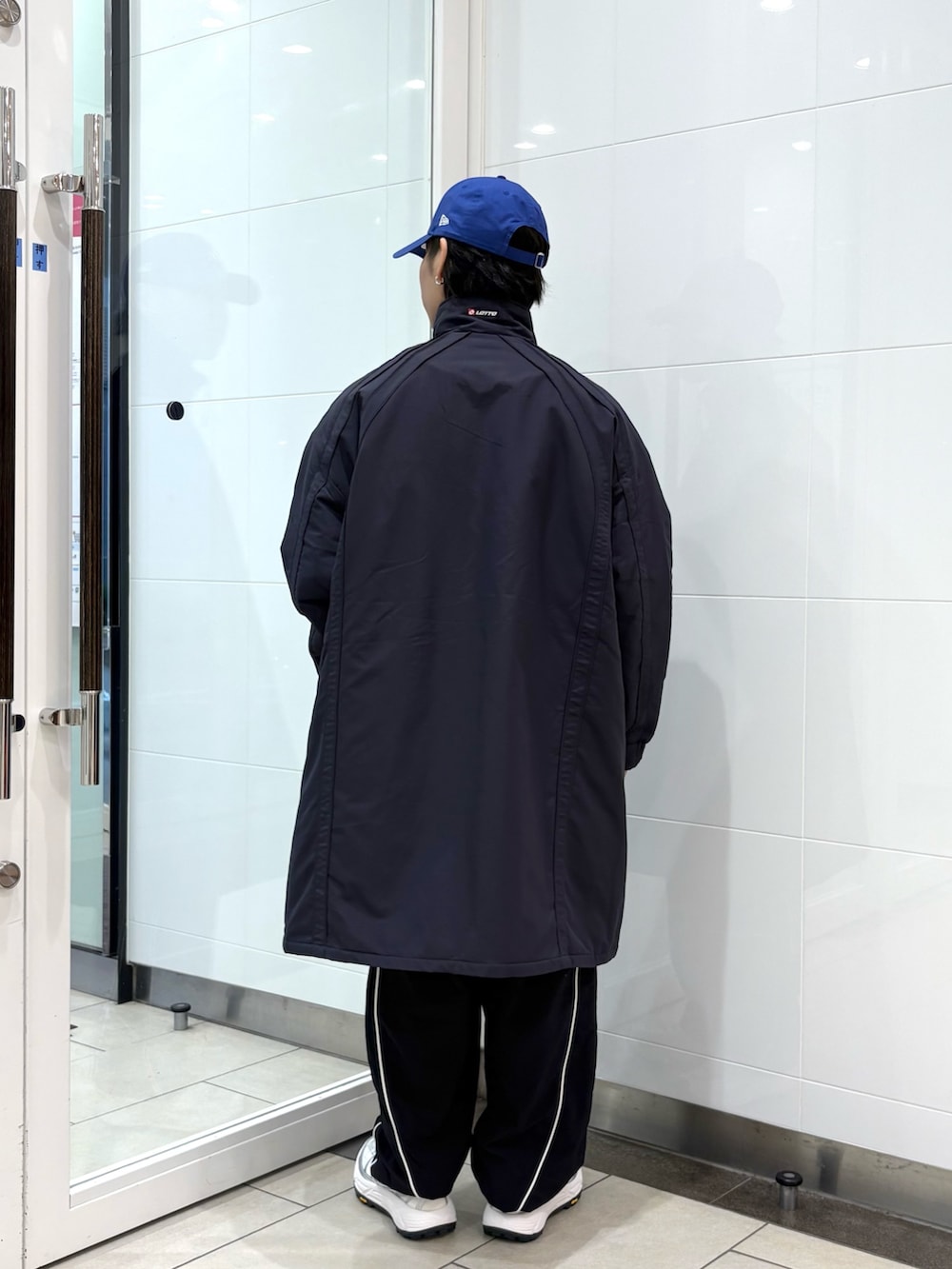 ブルー系のダウンジャケット/コート、ブラック系のその他パンツ、ホワイト系のスニーカーを着用したメンズの秋コーディネートの3枚目の写真