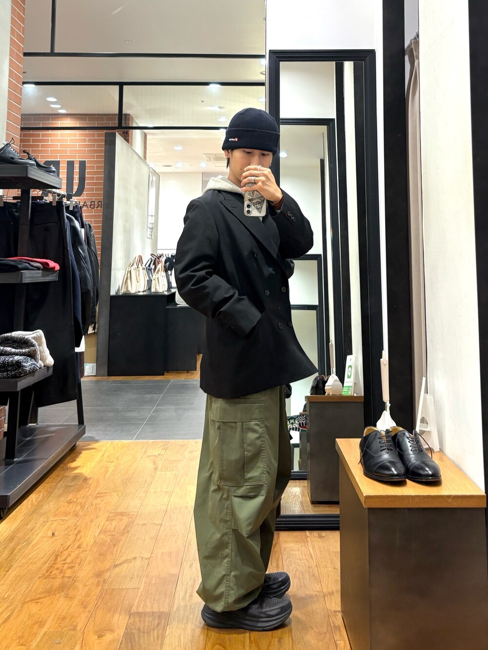グリーン系のその他アウター、グレー系のパーカー、ブラック系のニットキャップ/ビーニーを着用したメンズの冬コーディネートの3枚目の写真