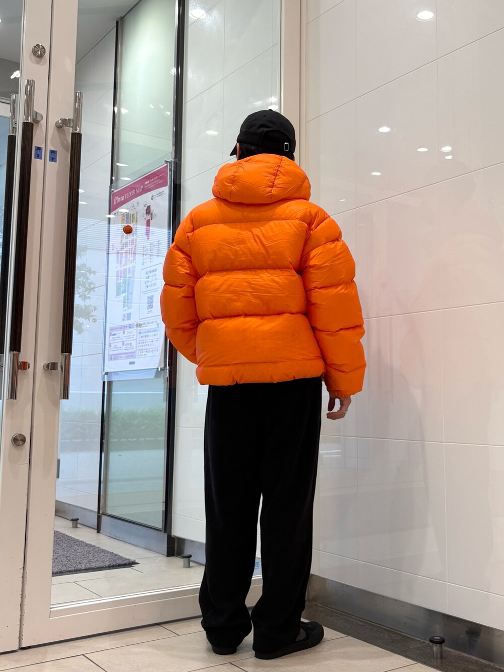 レッド系のダウンジャケット/コート、ブラック系のその他パンツ、ブラック系のキャップを着用したメンズの秋コーディネートの3枚目の写真