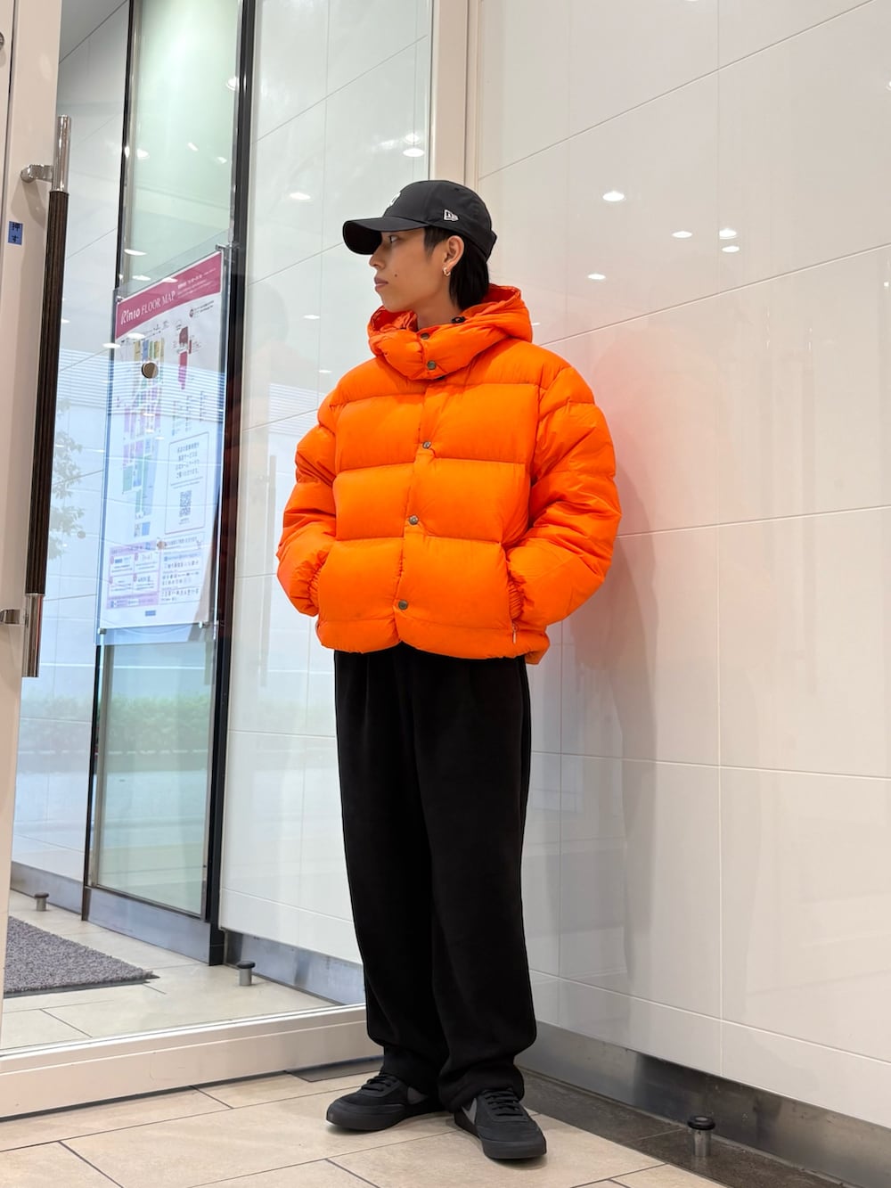 レッド系のダウンジャケット/コート、ブラック系のその他パンツ、ブラック系のキャップを着用したメンズの秋コーディネートの5枚目の写真