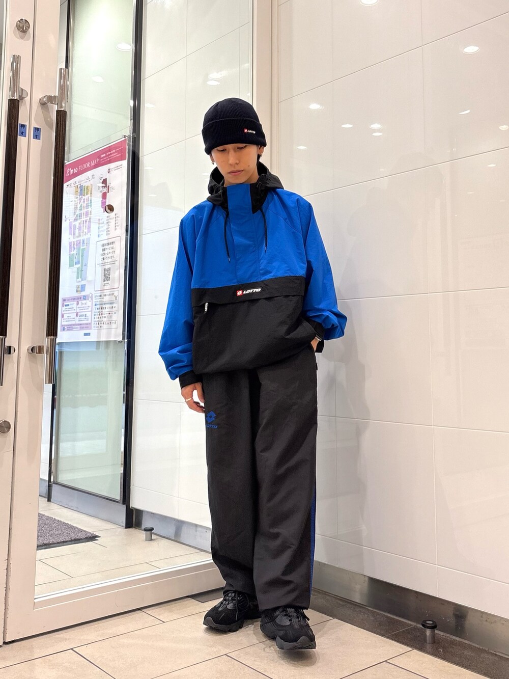 ブルー系のナイロンジャケット、ブルー系のその他パンツ、ブラック系のスニーカーを着用したメンズの秋コーディネートの6枚目の写真