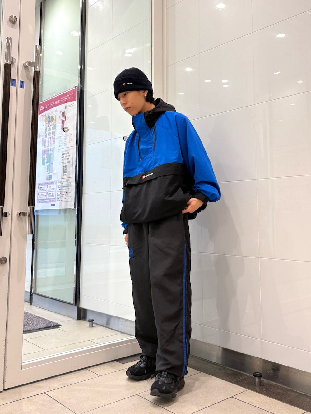 ブルー系のナイロンジャケット、ブルー系のその他パンツ、ブラック系のスニーカーを着用したメンズの秋コーディネートの2枚目の写真